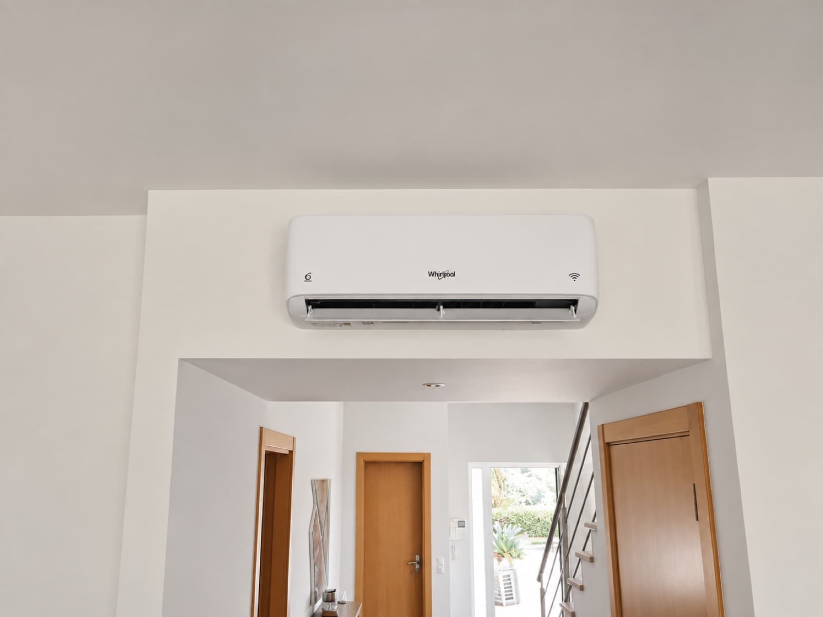 Ar condicionado Whirlpool instalado por cima de uma entrada, com escadas ao fundo