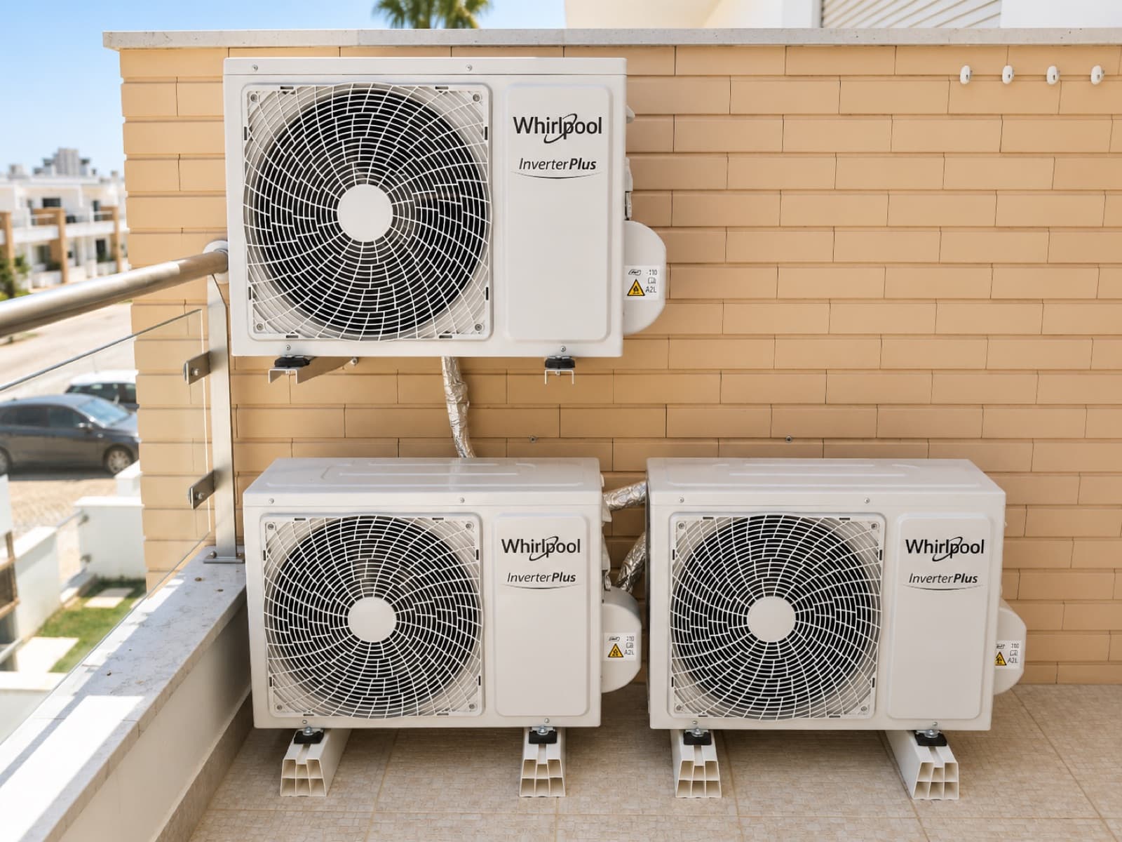 Três unidades exteriores de ar condicionado Whirlpool montadas numa varanda