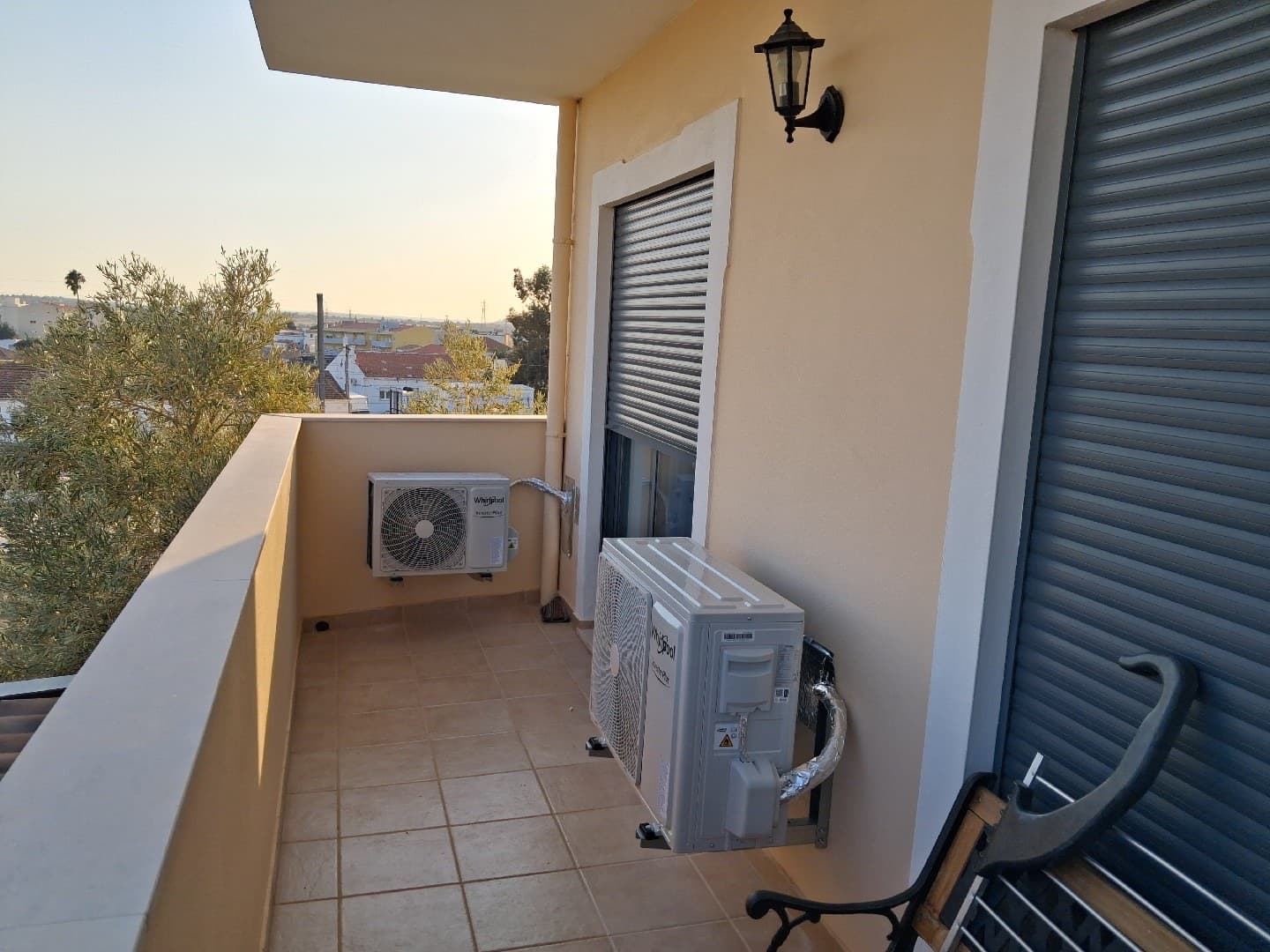 Outdoor air conditioning units installed on a balcony at sunset