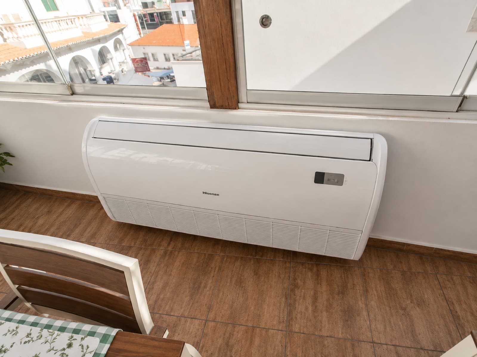 Unidade de ar condicionado Hisense instalada numa varanda com vista sobre a cidade