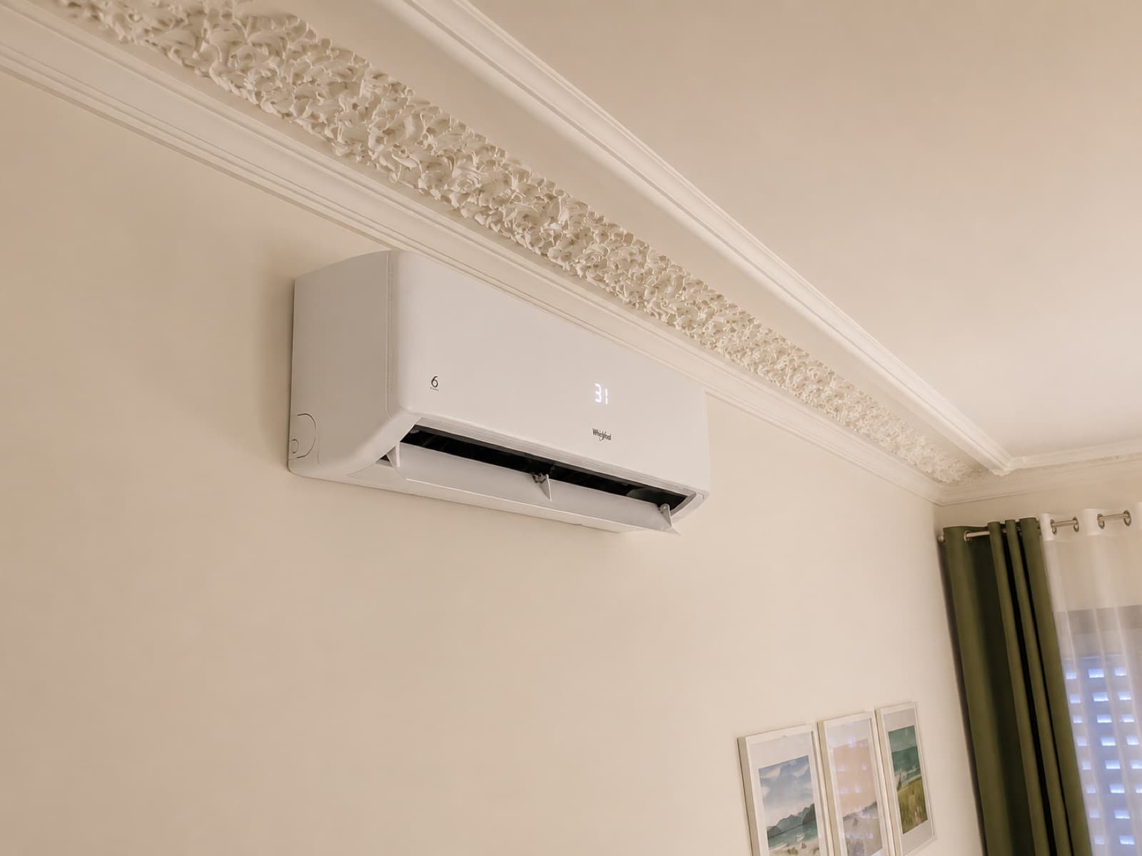 Ar condicionado Whirlpool instalado numa sala de estar, com moldura de teto decorativa