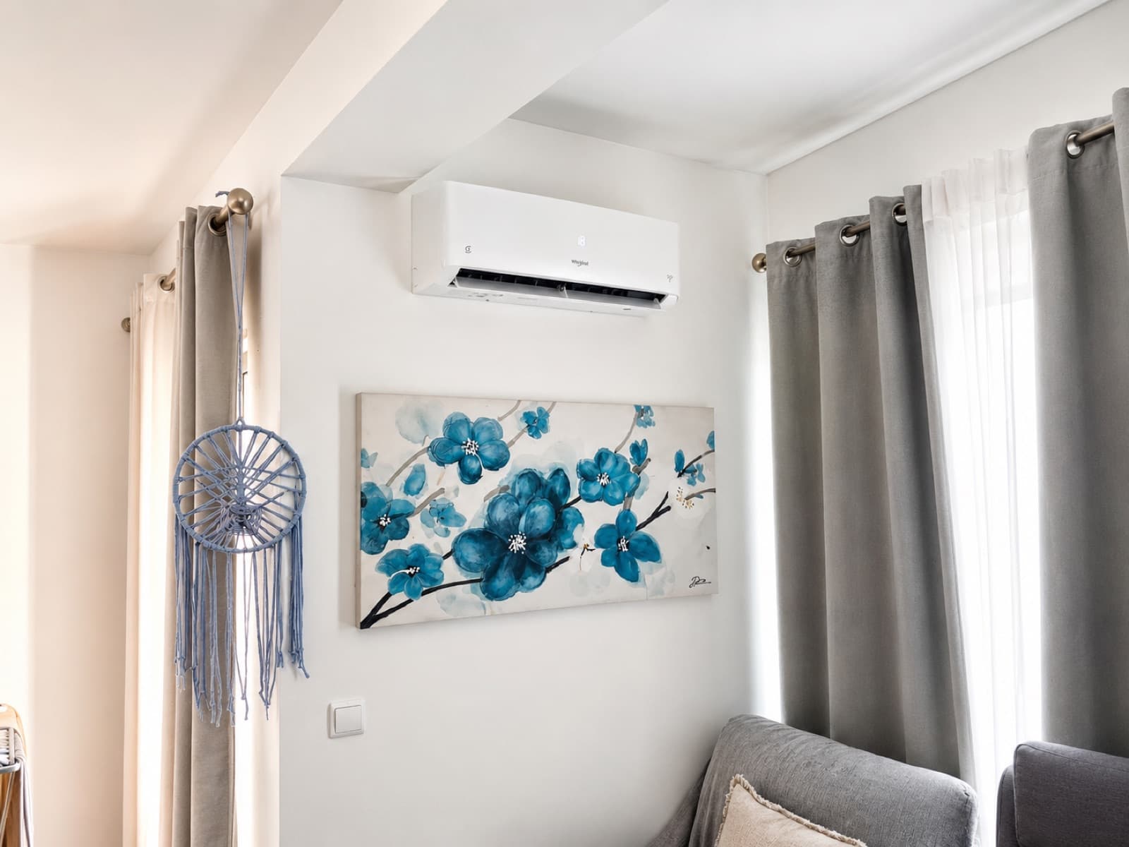 Ar condicionado Whirlpool instalado numa sala de estar, por cima de um quadro floral