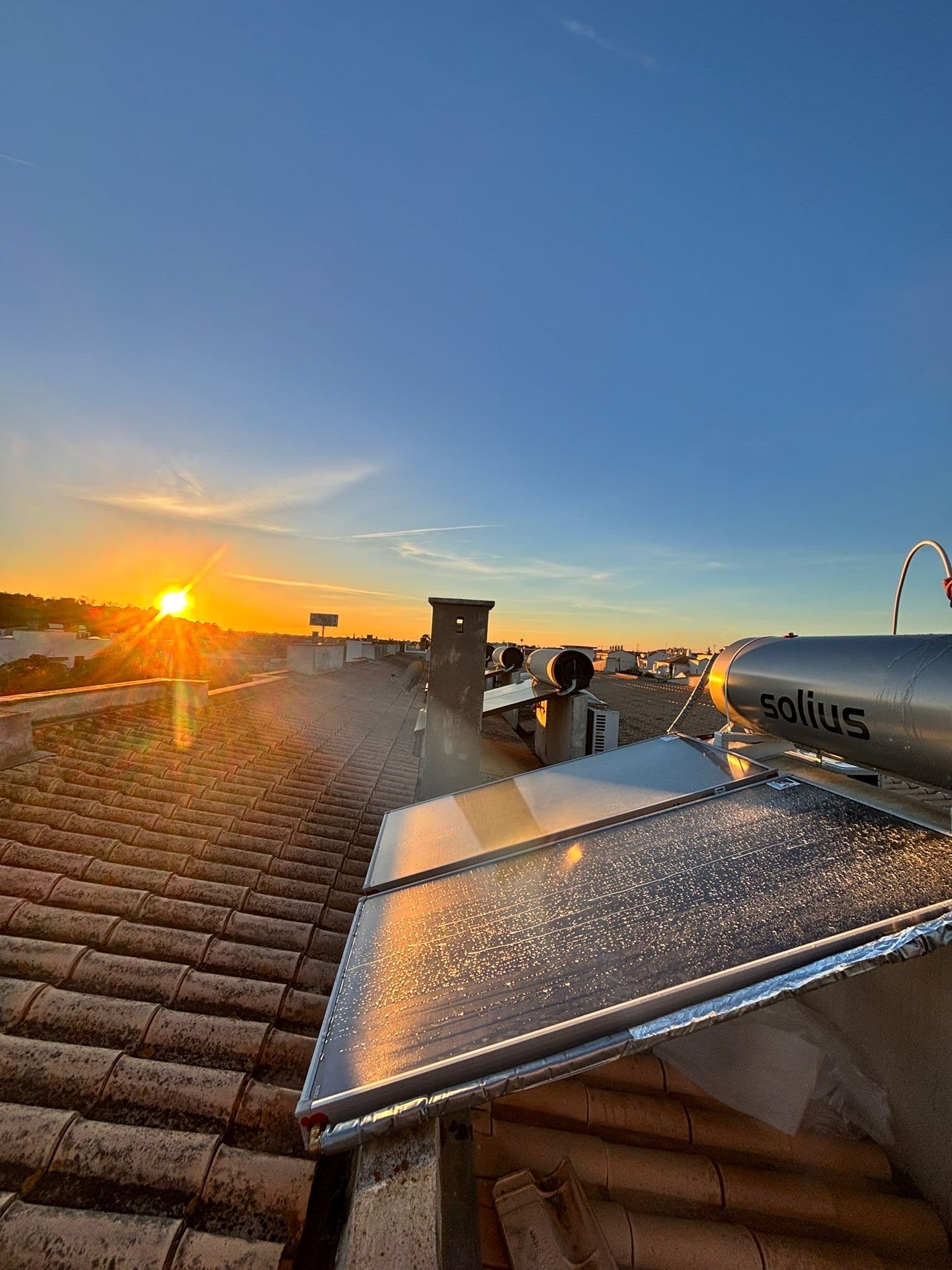 Solius solar thermal panel installed on a rooftop at sunset